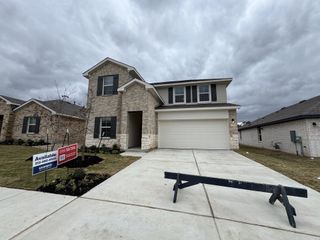 A charming brick home with a spacious driveway in Bar W Ranch by D.R. Horton (Leander, TX).