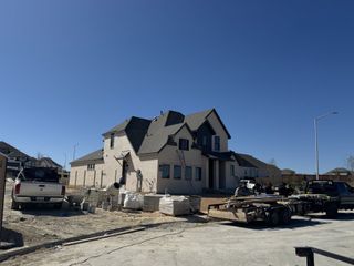 Street view A modern brick home under construction in Homestead by Highland Homes (Schertz, TX).
