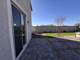 A sleek patio with paving stones and a manicured lawn in Bethany Grove by Beazer Homes (Glendale, AZ).