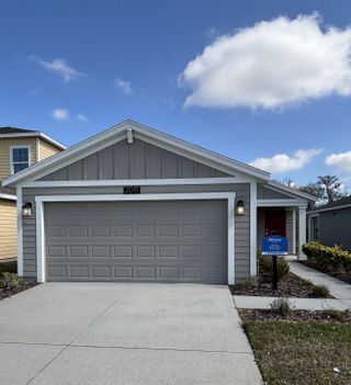 Street view A charming gray home with a spacious garage and inviting walkway in Storey Creek: Manor Collection by Lennar (Kissimmee, FL).