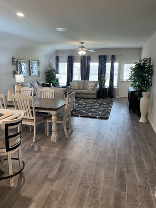 Model Home An inviting living space featuring a cozy seating area, wooden flooring, and abundant natural light with elegant decor.