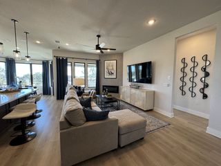 A cozy living area with plush seating, a modern fireplace, and a wall of windows showcasing the serene outdoors.