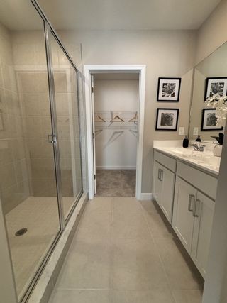 A modern bathroom with a spacious glass shower, sleek vanity, and elegant wall art.