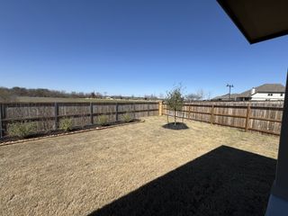 A spacious backyard with a new fence and manicured lawn in Venado Crossing by Beazer Homes (Cibolo, TX).