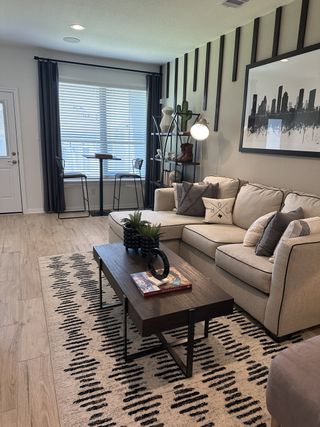 A cozy living room featuring a sleek sectional, modern art, and a chic coffee table over a patterned rug.