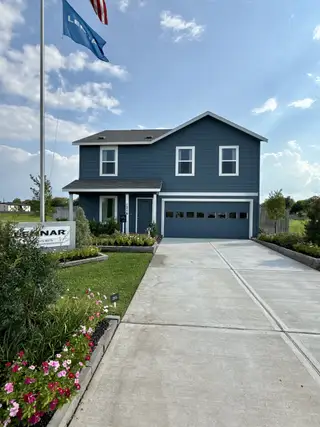 A modern blue two-story home with a manicured lawn in Wharton Lakes: Watermill Collection by Lennar (Wharton, TX).
