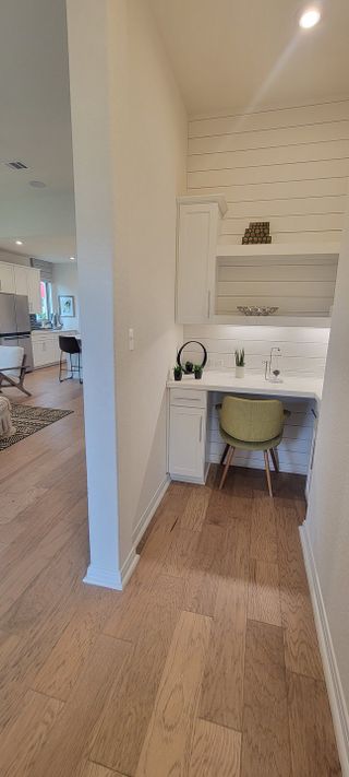 A built-in study nook with a white desk, storage cabinets, and a stylish chair, creating a functional workspace in a Davis Ranch home by Coventry Homes (San Antonio, TX).