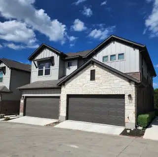 Street view A modern two-story home with stone accents and a spacious garage in Sonoma Heights by Coventry Homes (Round Rock, TX).