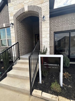 A charming brick entryway with stone accents and modern lighting in Vista Ridge by HistoryMaker Homes (Live Oak, TX).