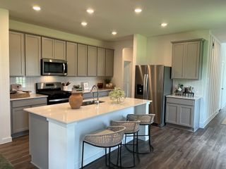 Modern kitchen with sleek cabinets, stainless appliances, and a spacious island with seating and quartz countertops.