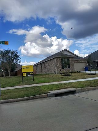 Street view A modern brick home with a manicured lawn in Lakewood Pines Trails by KB Home (Houston, TX).