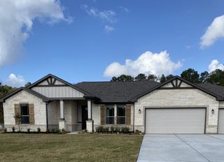 Model Home A charming stone facade home with a spacious garage in Barton Place by First America Homes (Cleveland, TX).