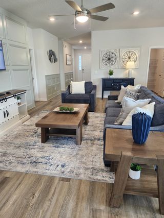 A cozy living room featuring a plush blue sofa, stylish wooden furniture, and elegant wall decor with soft lighting.