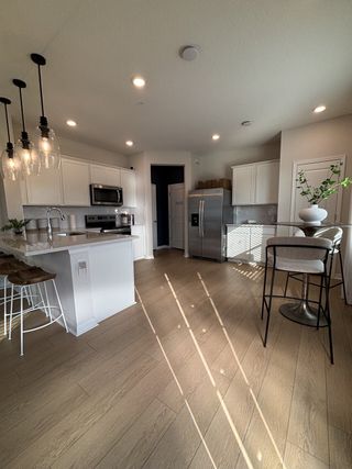 Model Home A beautifully designed kitchen with pendant lighting, stainless steel appliances, and a large island in Emerald Pointe by Pulte Homes (Apopka, FL).