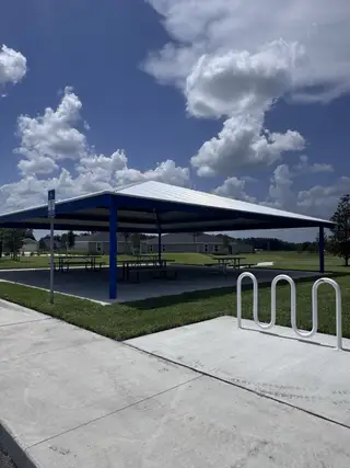 A modern park pavilion with picnic tables and bike racks in Holstein Crossing: Holstein Crossing 50s by Lennar (Green Cove Springs, FL).