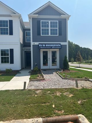 Street view A charming gray and white townhome with manicured landscaping in Thornton Townes by D.R. Horton (Raleigh, NC).