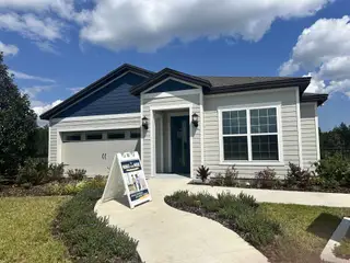 A charming blue-accented home with a landscaped yard in Westport Landing by LGI Homes (Jacksonville, FL).