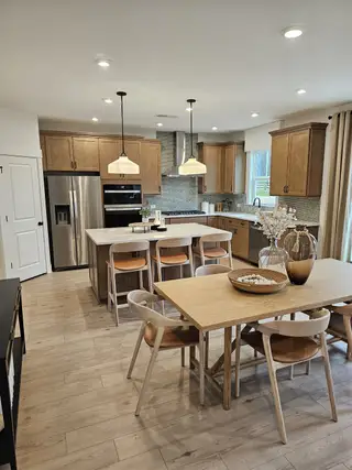 Model Home A stunning kitchen with warm wood cabinetry, sleek tile backsplash, and a spacious island for effortless cooking and entertaining.