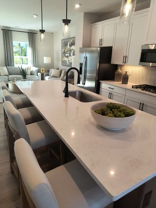 A contemporary kitchen with a large island, pendant lighting, stainless appliances, and an inviting open-plan layout.