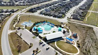 Aerial view of community amenities in Crosswinds by Pacesetter Homes, featuring a pool and playground in Kyle, TX.