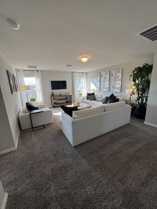 A spacious bathroom with a dual-sink vanity, large mirror, and tiled flooring in Blue Ridge Ranch by M/I Homes (San Antonio, TX).
