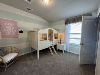 A charming kids' room with a cabin bed, striped walls, and coastal decor for a playful, serene atmosphere.