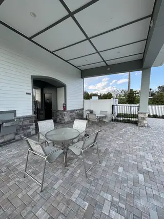 Model Home An inviting outdoor seating area with a covered patio and brick pavers in Emerald Pointe by Pulte Homes (Apopka, FL).