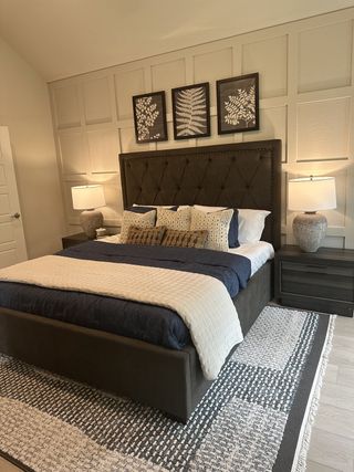 A cozy bedroom with a tufted bed, textured wall art, and soft lighting for a relaxing ambiance.