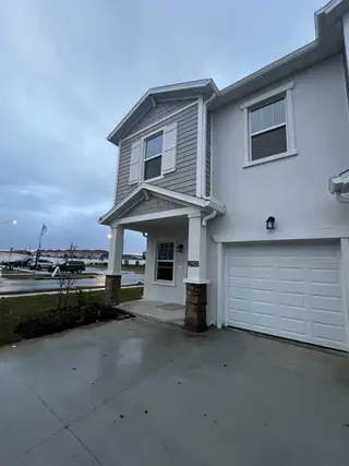 Street view Charming two-story home with grey siding and white accents in Astonia: Chateau at Astonia by Lennar (Davenport, FL).