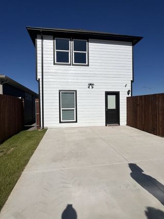 Street view A modern white home with sleek design and a spacious driveway in Orchard Village by D.R. Horton (Fort Worth, TX).