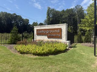 Street view Landscaped entrance to Campground Crossing by Dream Finders Homes in Mcdonough, GA, with a welcoming brick and metal sign.