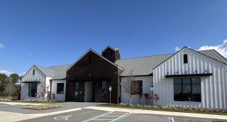 A modern building with metal roofs and wood accents in Harmony West by D.R. Horton (St. Cloud, FL).