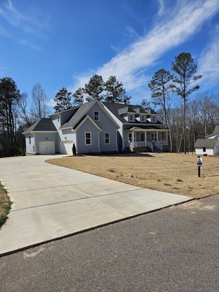 A beautiful gray home with spacious porch and expansive driveway in Old Town Estates by Vision Home Crafters (Dacula, GA).