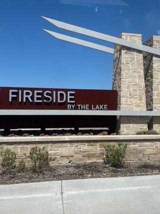 Street view A welcoming entrance sign of Fireside by the Lake by D.R. Horton in Garland, TX, framed by stone pillars and landscaping.