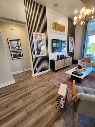 A stylish living room with accent wall detailing, a mounted TV, and elegant lighting, creating a cozy and modern ambiance.
