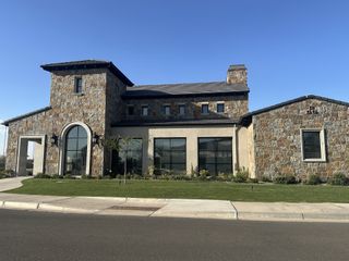 Community Amenities The clubhouse at Atrium at Somerset by Capital West Homes in Gilbert, AZ, showcases elegant stone architecture and a modern aesthetic.