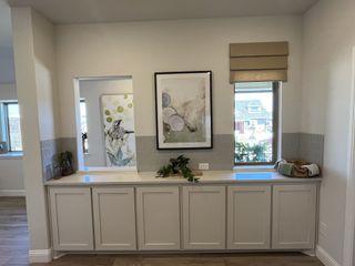 A bright and airy room with elegant cabinetry, neutral tones, and tasteful artwork for a serene atmosphere.