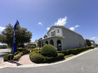 A charming gray home with arched entryway and lush landscaping in Waterleigh by D.R. Horton (Winter Garden, FL).