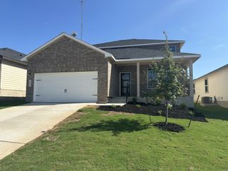 Brick home with a spacious garage and manicured lawn in Royal Crest by Davidson Homes LLC (San Antonio, TX).