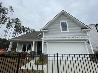 A charming gray home with a front porch in North Creek at Nexton by True Homes (Summerville, SC).