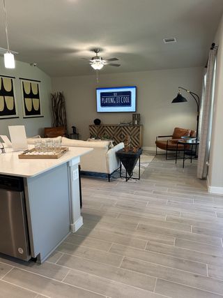A modern living room with sleek furniture, stylish decor, and light wooden tile flooring.