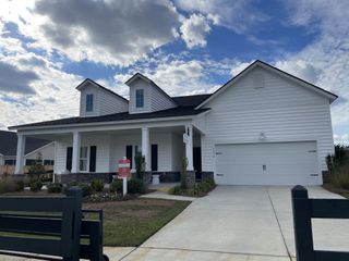 A charming white home with a covered porch in Sweetgrass at Summers Corner: Row Collection by Lennar (Ridgeville, SC).