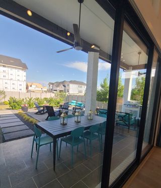 A modern patio with a sleek dining set, vibrant blue chairs, and cozy seating, perfect for outdoor gatherings.