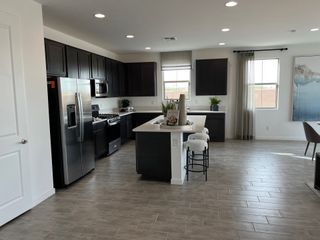 A modern kitchen with dark cabinetry, stainless steel appliances, and a central island with bar seating.