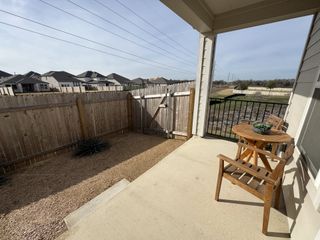 A cozy patio with wooden furniture and a fenced yard, perfect for relaxing outdoors.
