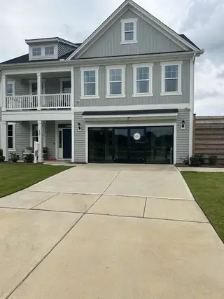 Street view A charming gray siding home with inviting porch in Cornwallis Landing by Mungo Homes (Garner, NC).