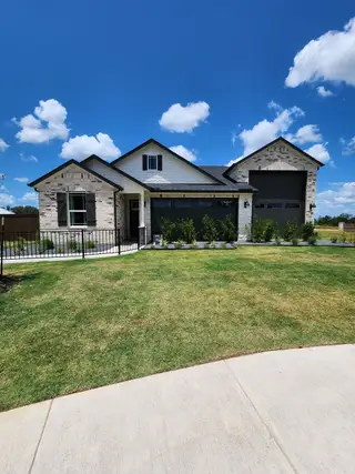 A charming brick home with modern accents and a lush yard in Shoreside at Gregg Ranch by Richmond American Homes (Marble Falls, TX).