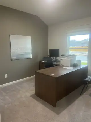 A professional office space with a large desk, modern chair, and ample natural light. Perfect for productivity and focus.