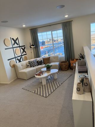 A cozy living area with a plush sectional sofa, modern decor, and a scenic view from large windows.