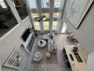 Model Home A spacious living area with large windows, sleek furniture, and elegant decor, featuring a modern open layout and balcony view.